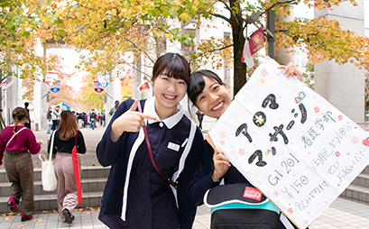 アロママッサージの看板を掲げる女子在学生たち