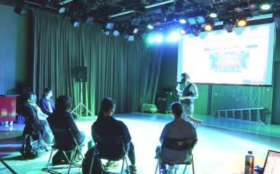 地下スタジオで、ステージにおける照明や音響の効果について話す中川晃助教
