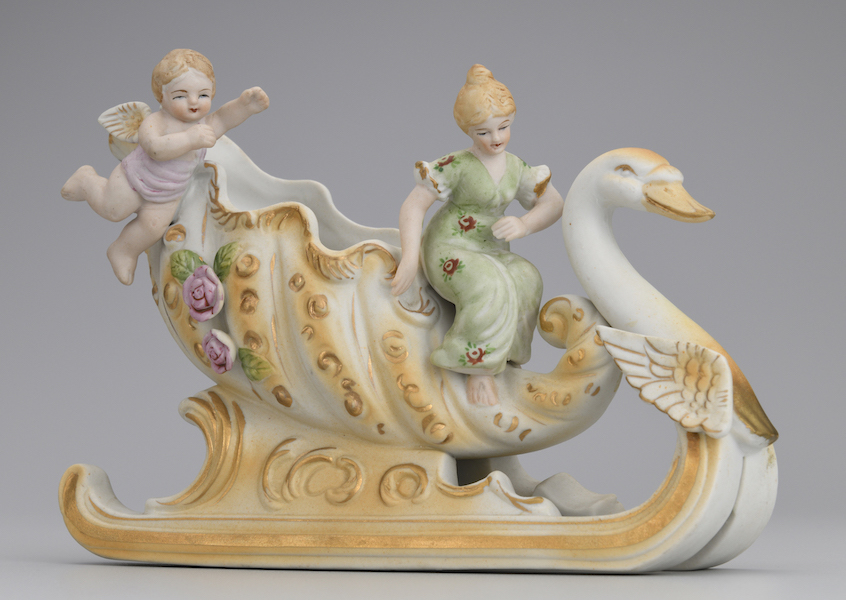 Centerpiece of a Woman Riding a Swan-Type Sleigh and an Angel